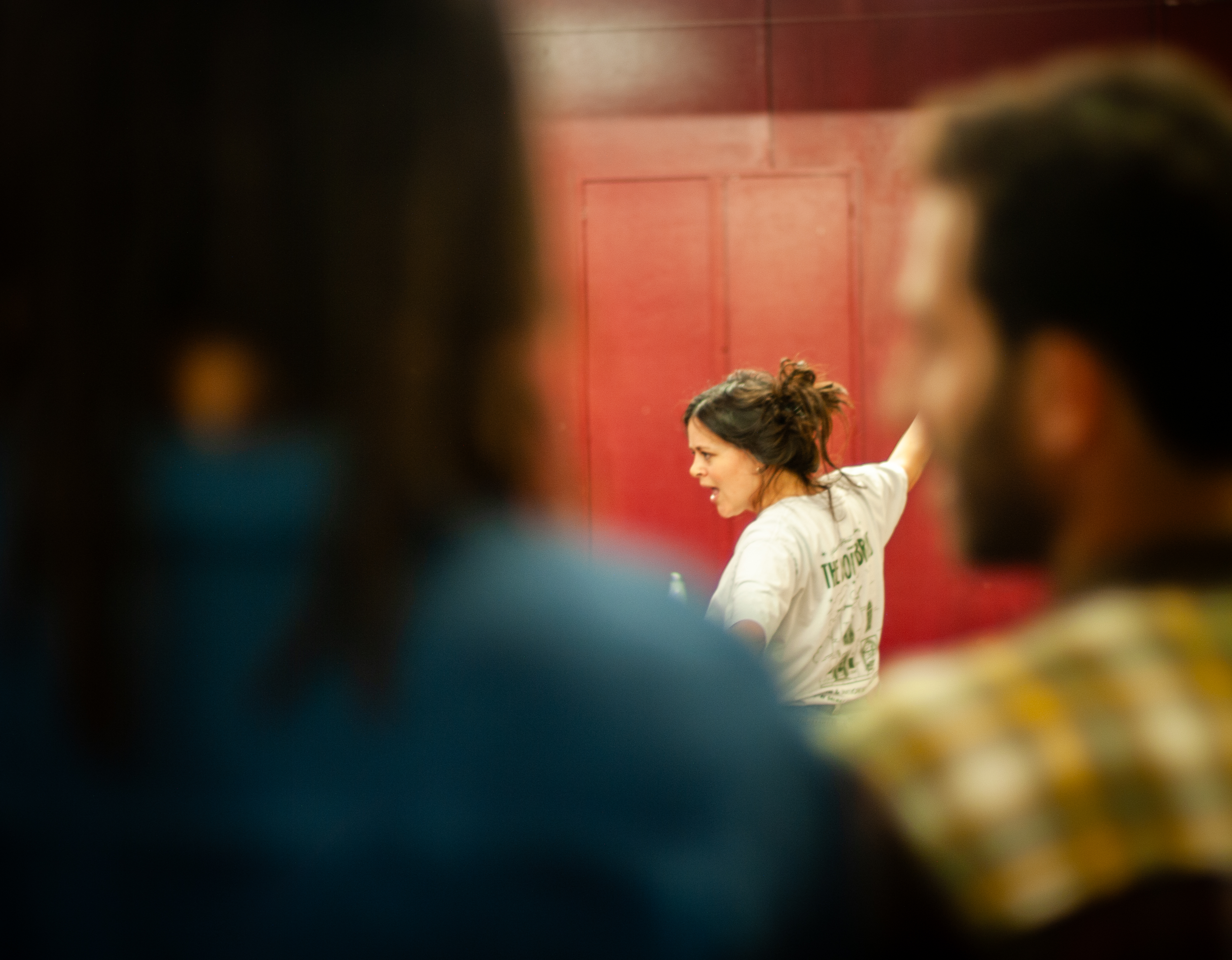 Performer framed between observers against a red wall